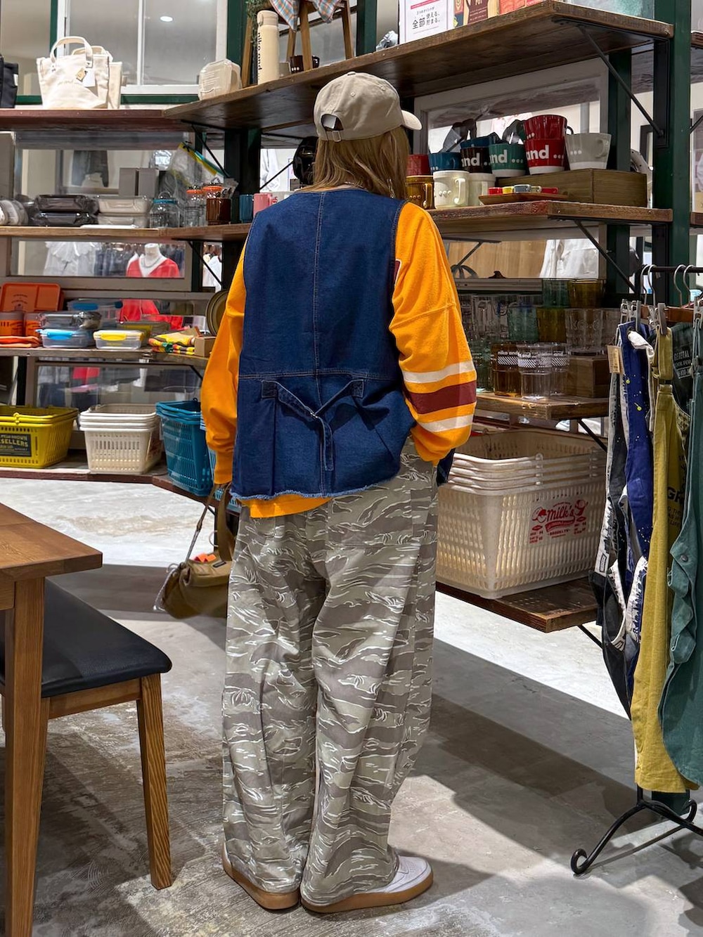 ブルー系のベスト、ベージュ系のキャップを着用したレディースの春コーディネートの6枚目の写真