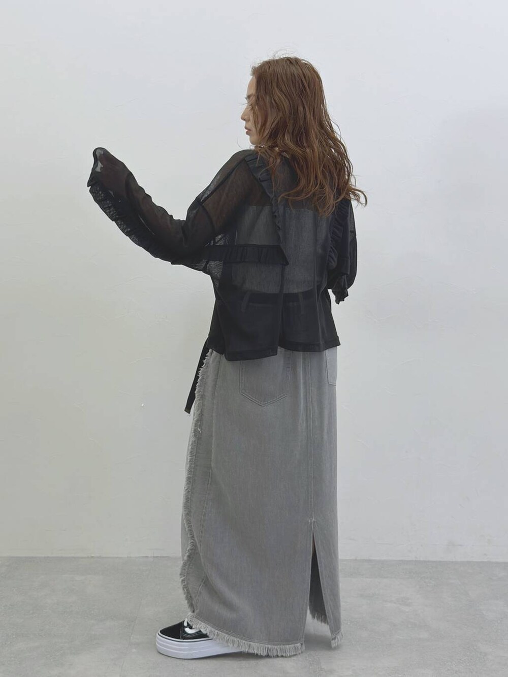 グレー系のデニムスカート、ブラック系のTシャツ/カットソーを着用したレディースの冬コーディネートの3枚目の写真