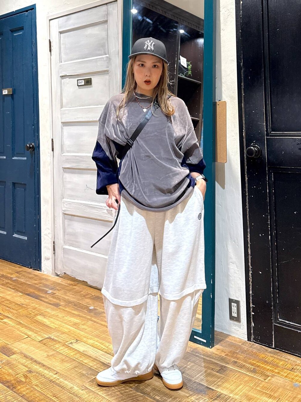 グレー系のTシャツ/カットソー、ブラック系のショルダーバッグ、ブラック系のキャップを着用したレディースの夏コーディネートの2枚目の写真