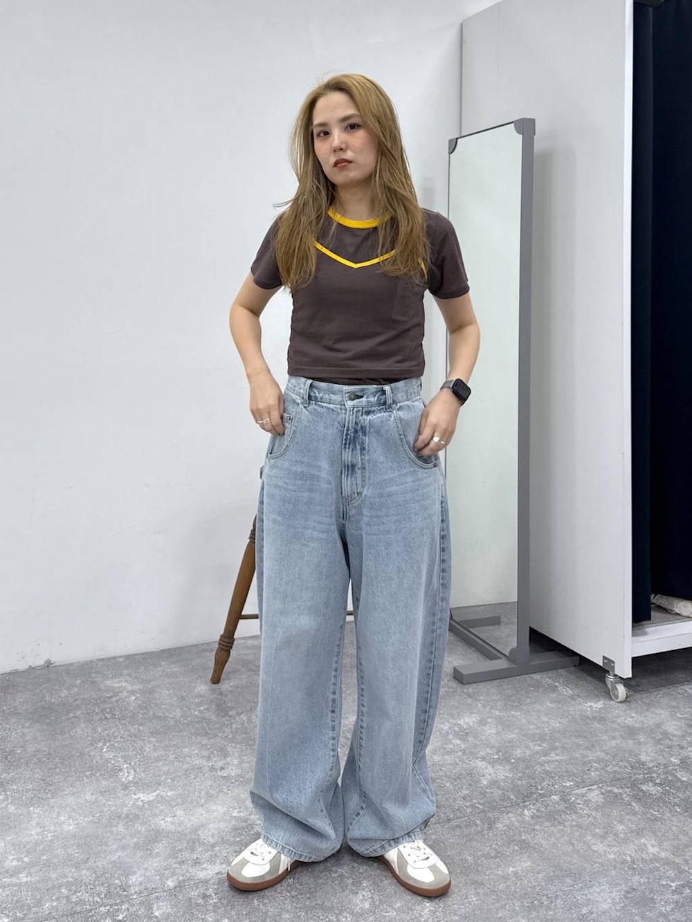 ベージュ系のスニーカー、ブラウン系のTシャツ/カットソー、ブルー系のデニムパンツを着用したレディースの春コーディネートの3枚目の写真