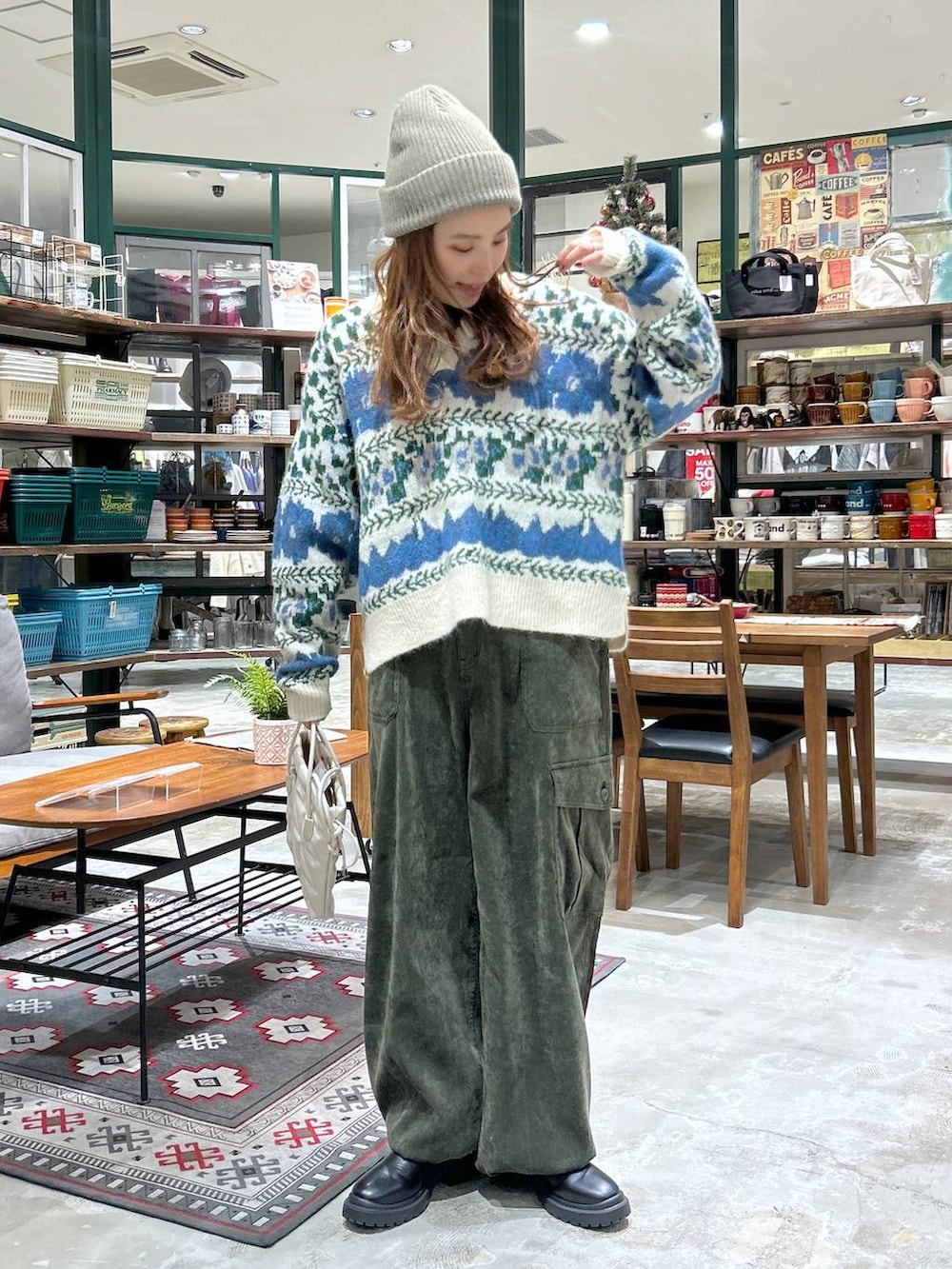 ベージュ系のショルダーバッグ、ブラック系のブーツ、グリーン系のカーゴパンツを着用したレディースの冬コーディネートの2枚目の写真