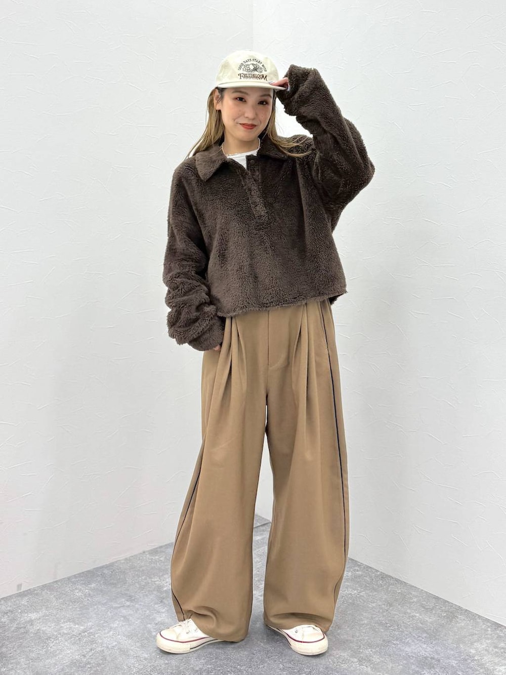 ブラウン系のポロシャツを着用したレディースの秋コーディネートの2枚目の写真