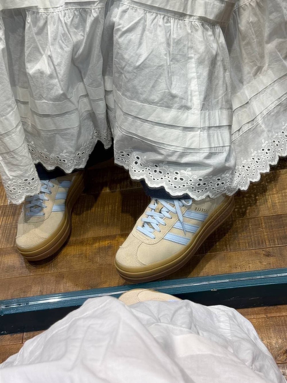 ベージュ系のスニーカー、レッド系のキャップを着用したレディースの春コーディネートの2枚目の写真