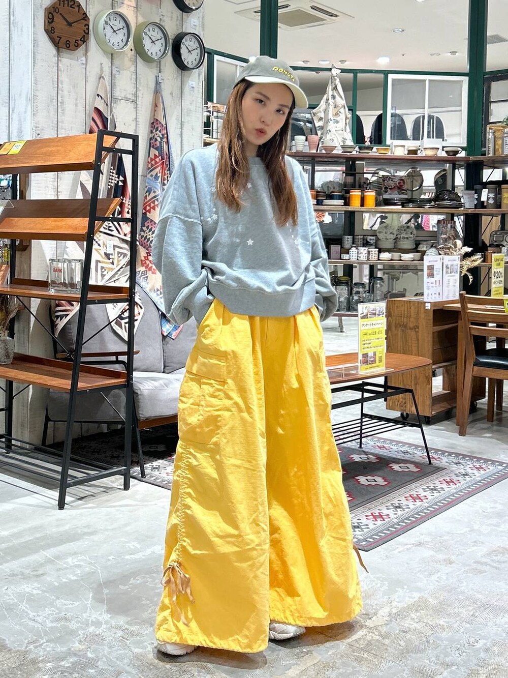 グレー系のスウェット、グリーン系のキャップを着用したレディースの冬コーディネートの3枚目の写真