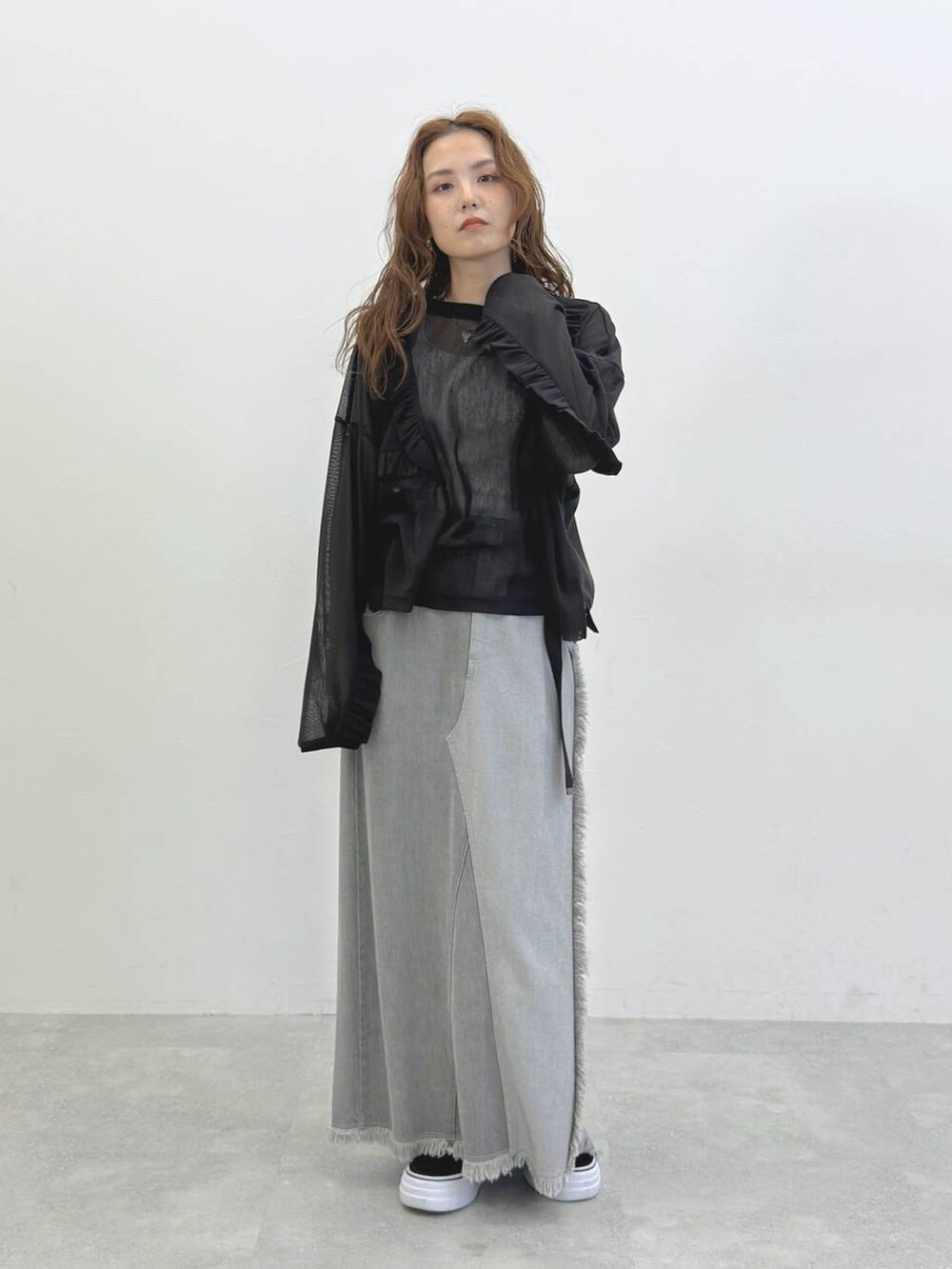 グレー系のデニムスカート、ブラック系のTシャツ/カットソーを着用したレディースの冬コーディネートの2枚目の写真