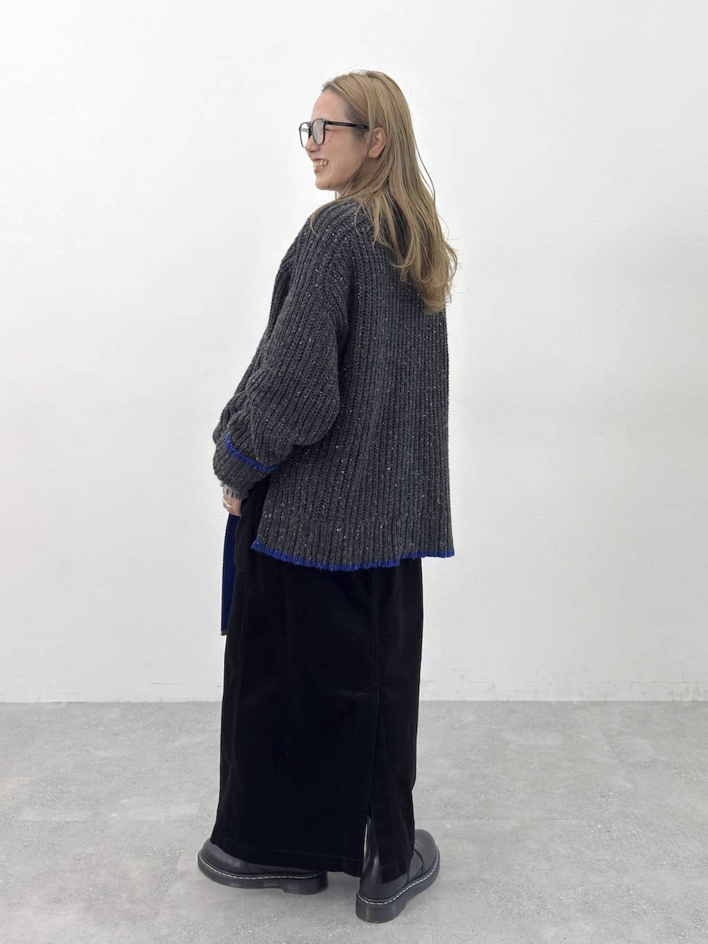 グリーン系のシャツ/ブラウス、ブラック系のニット/セーター、ブラック系のスカートを着用したレディースの秋コーディネートの4枚目の写真