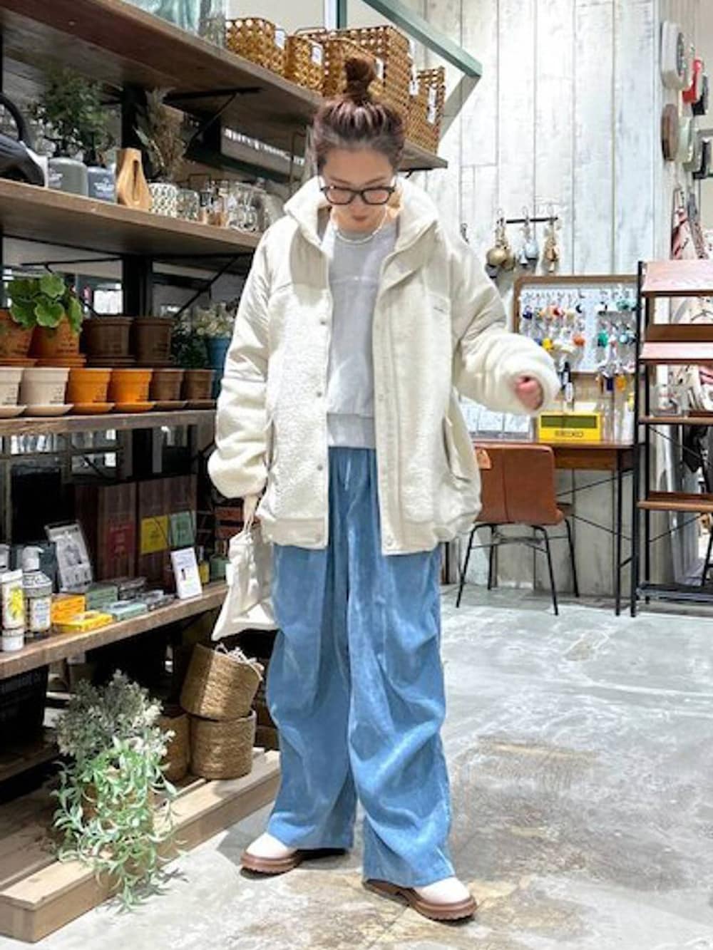 ホワイト系のトートバッグ、ベージュ系のその他アウター、ベージュ系のブーツを着用したレディースの冬コーディネートの2枚目の写真