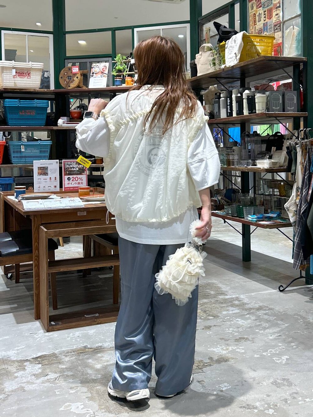 グレー系のスニーカー、ベージュ系のベスト、ベージュ系のショルダーバッグを着用したレディースの夏コーディネートの2枚目の写真