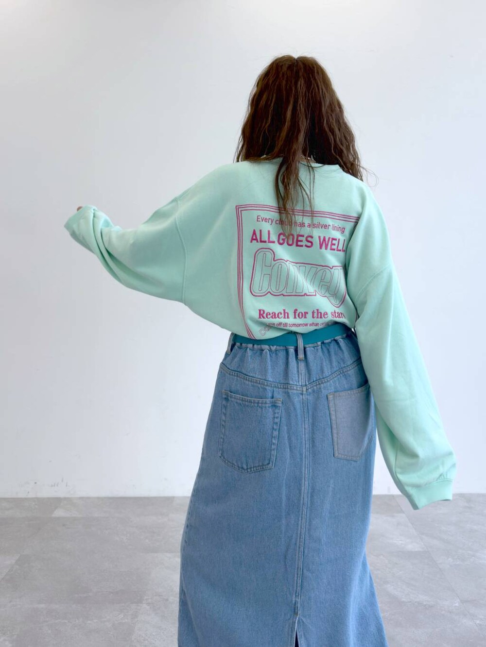 ブルー系のデニムスカート、グリーン系のTシャツ/カットソーを着用したレディースの冬コーディネートの6枚目の写真