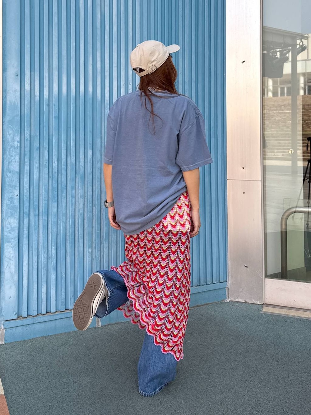 ブルー系のデニムパンツ、ピンク系のスカート、ベージュ系のキャップを着用したレディースの春コーディネートの4枚目の写真