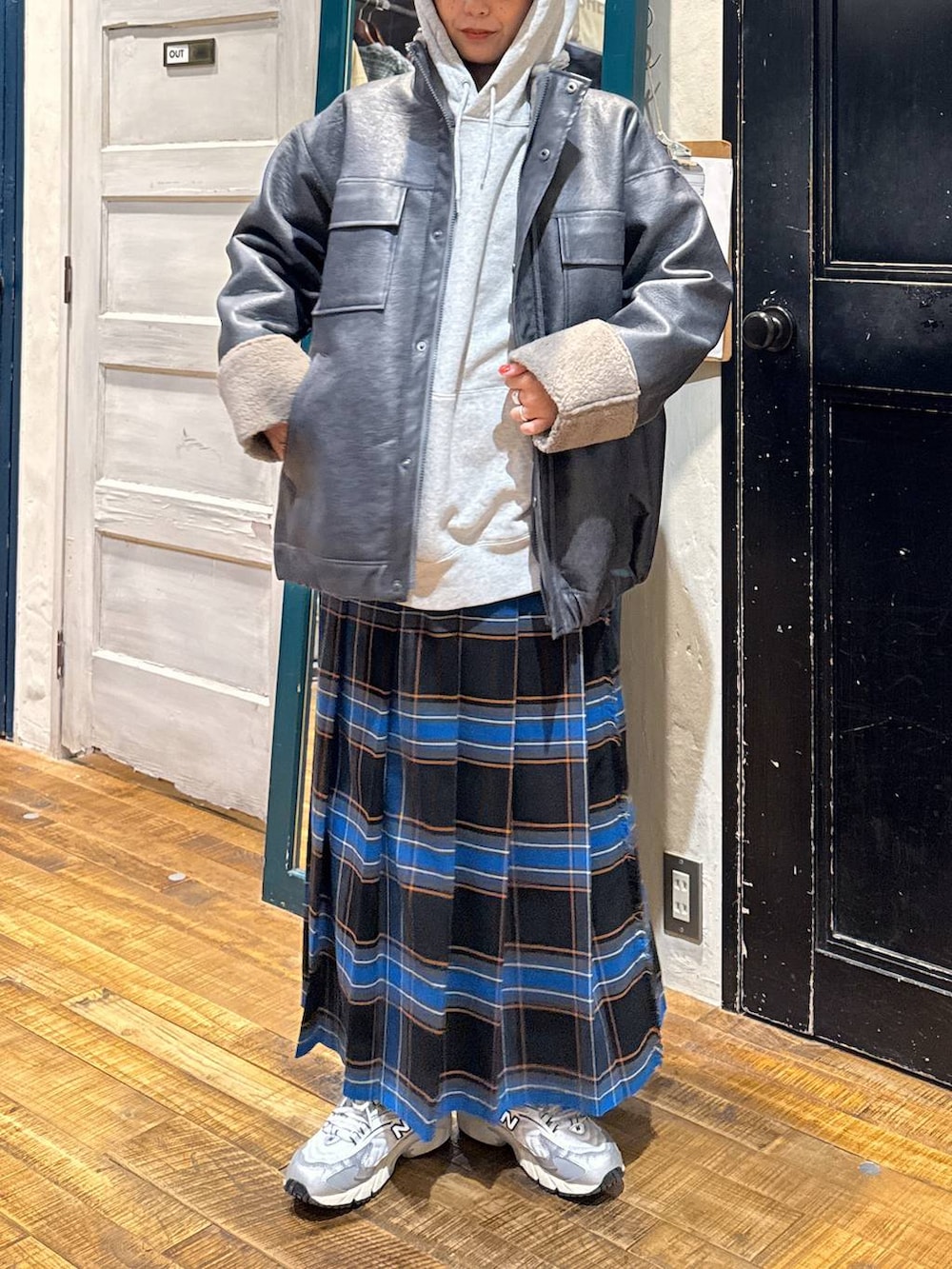 ブラック系のスカート、グレー系のパーカー、グレー系のブルゾンを着用したレディースの冬コーディネートの2枚目の写真