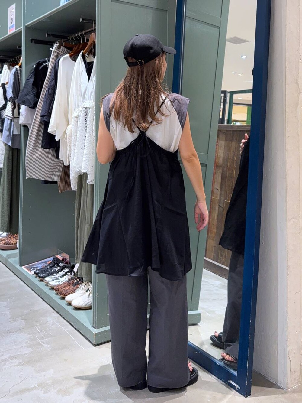 グレー系のチノパンツ、ホワイト系のTシャツ/カットソー、ブラック系のワンピースを着用したレディースの夏コーディネートの3枚目の写真