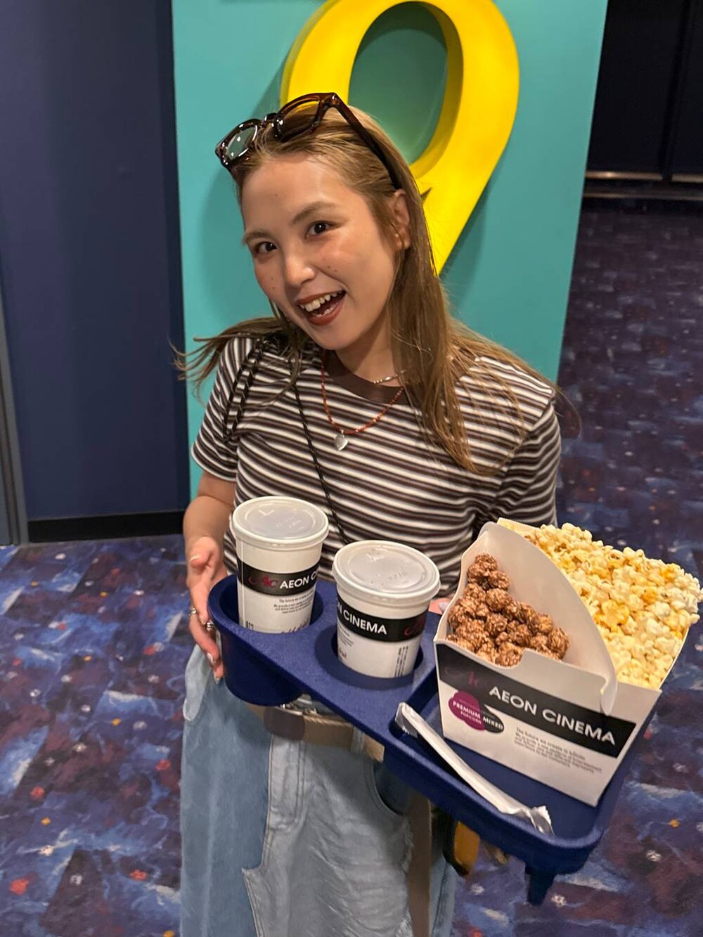 ベージュ系のショルダーバッグ、ブルー系のデニムスカート、ブラウン系のコインケースを着用したレディースの春コーディネートの2枚目の写真