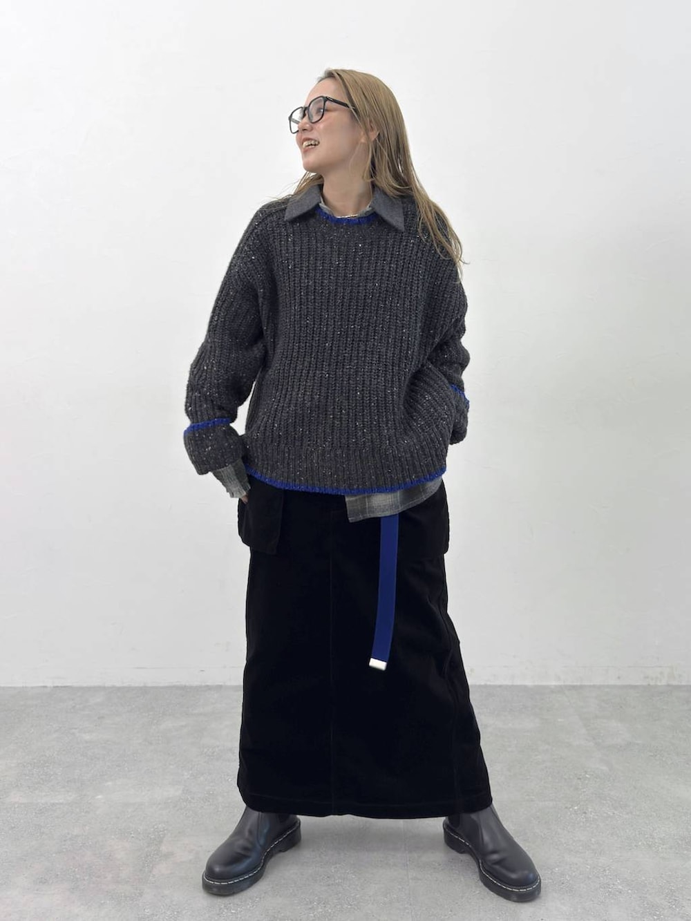 グリーン系のシャツ/ブラウス、ブラック系のニット/セーター、ブラック系のスカートを着用したレディースの秋コーディネートの2枚目の写真