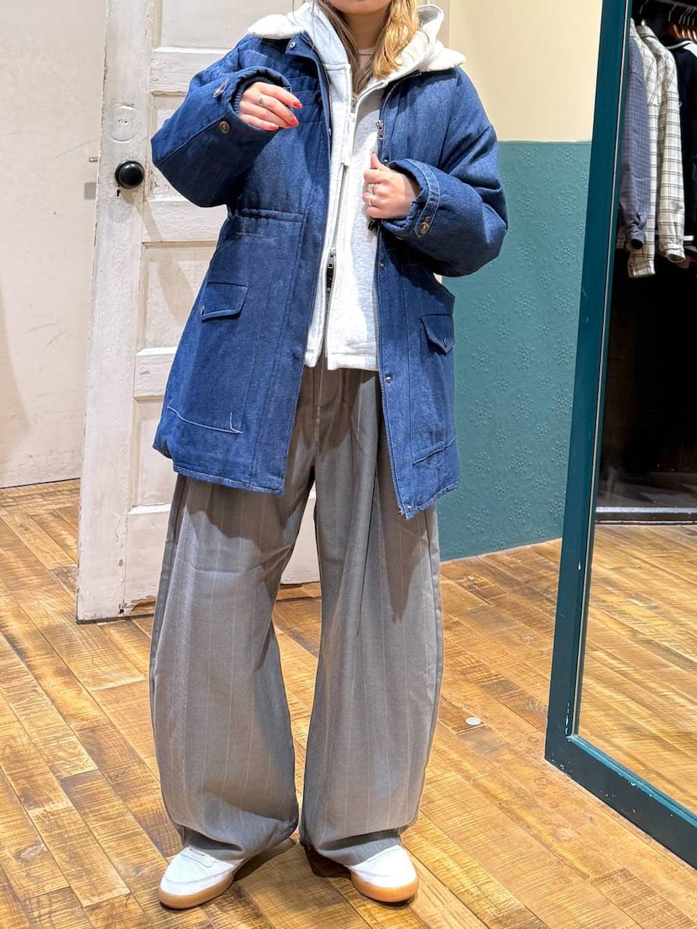 グレー系のパーカー、ホワイト系のキャップを着用したレディースの冬コーディネートの2枚目の写真