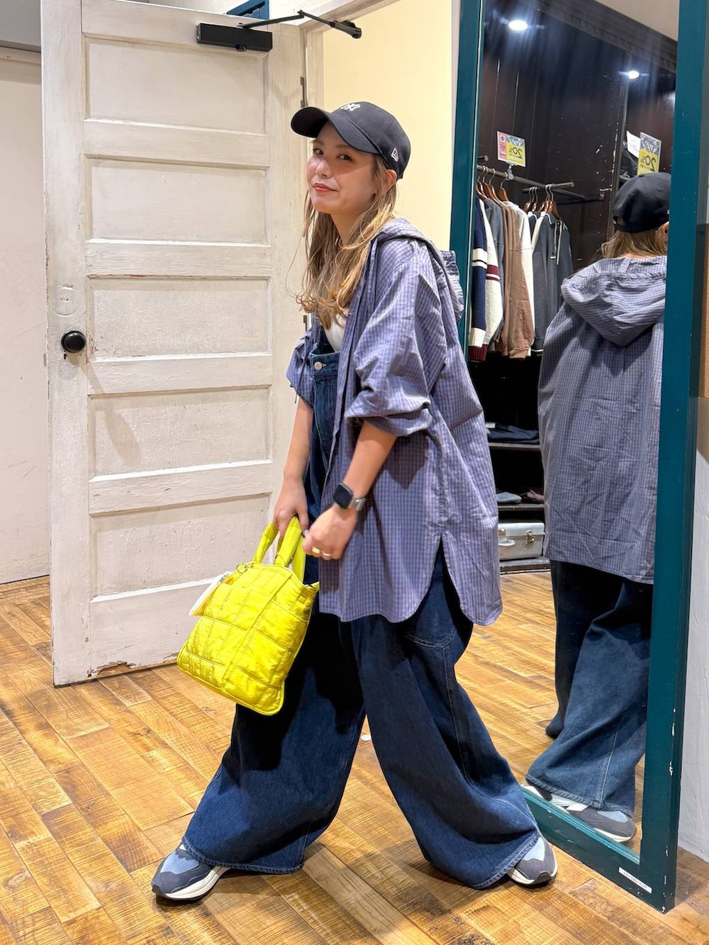 ベージュ系のタンクトップ、イエロー系のトートバッグを着用したレディースの秋コーディネートの3枚目の写真