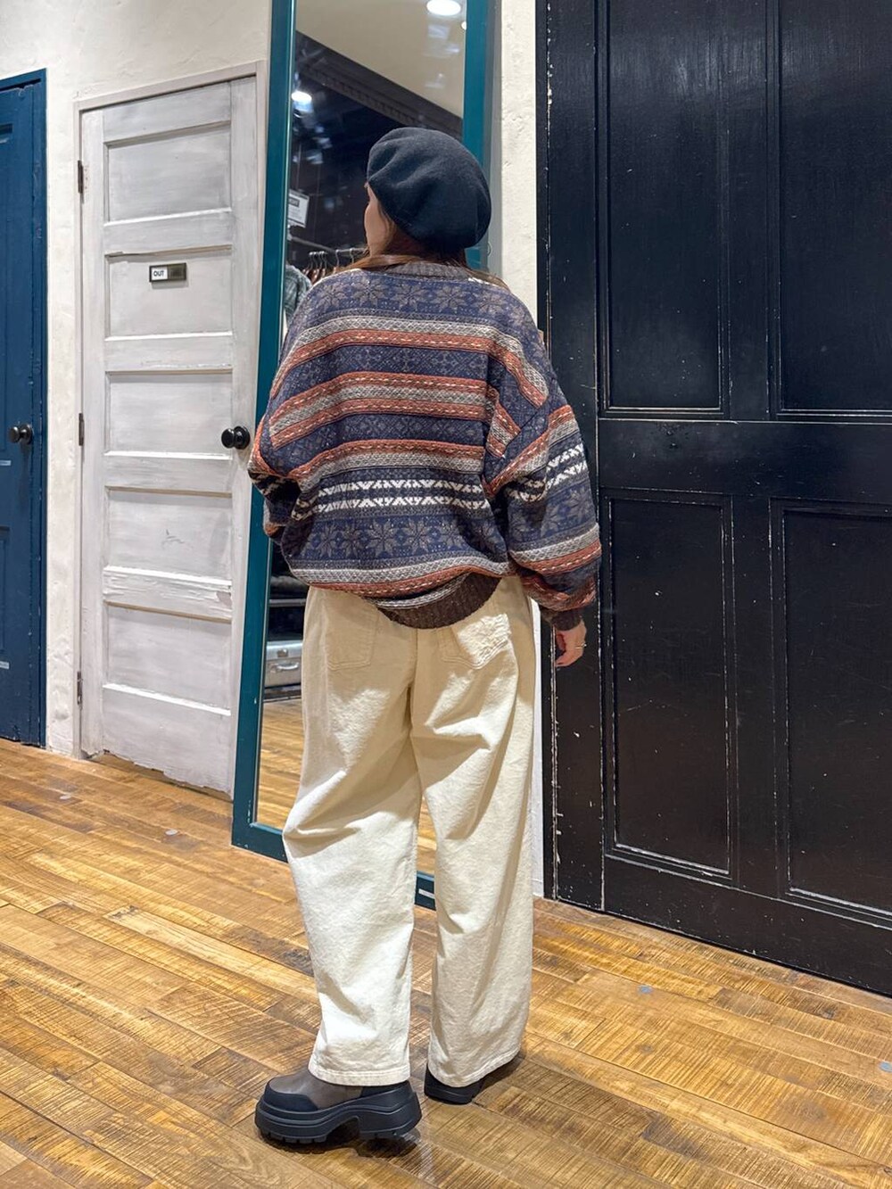 ブラウン系のブーツ、ブラウン系のニット/セーター、ブラック系のハンチング/ベレー帽を着用したレディースの冬コーディネートの3枚目の写真