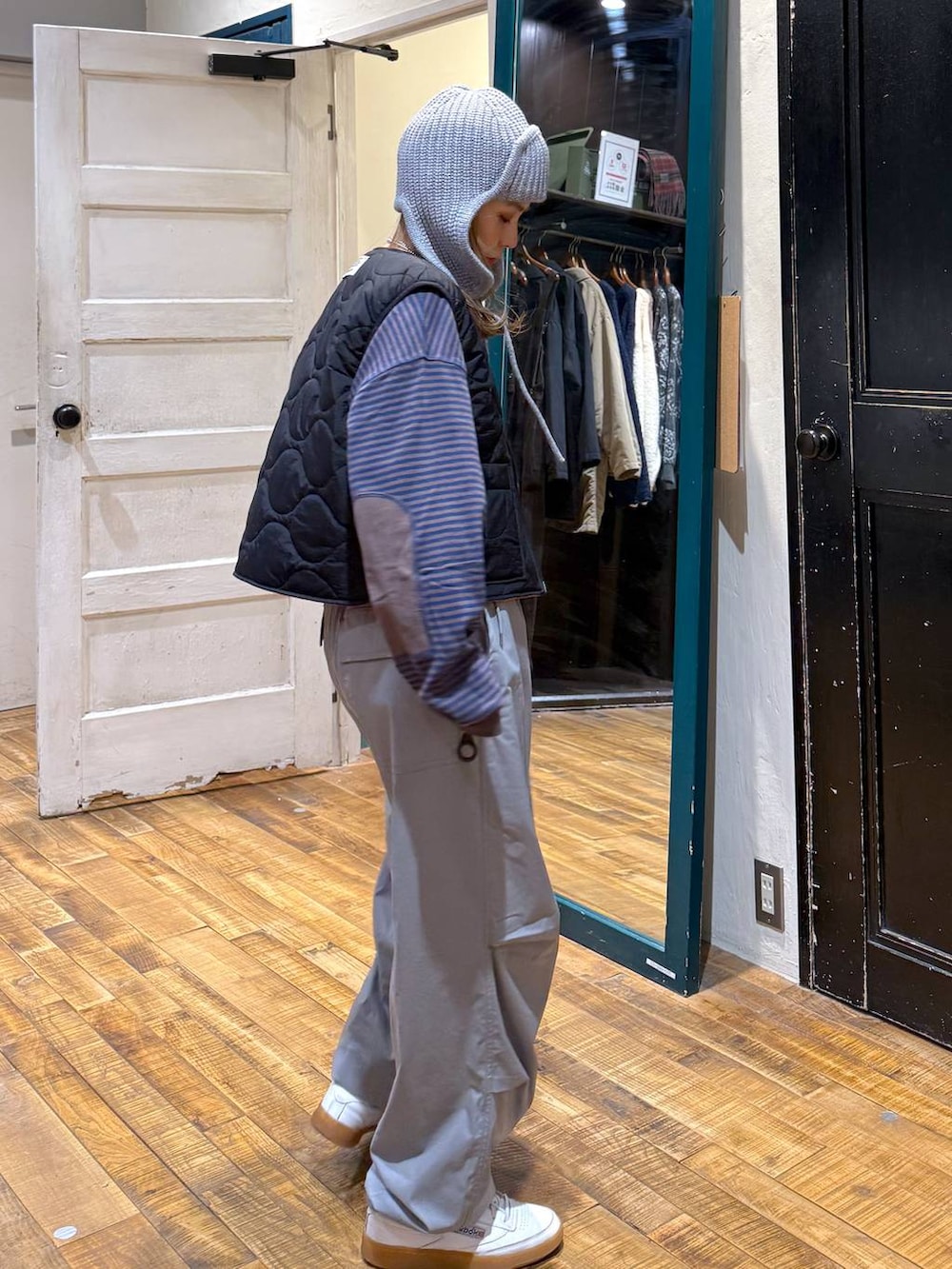 ブラウン系のTシャツ/カットソー、グレー系のその他パンツ、ブラック系のベストを着用したレディースの冬コーディネートの2枚目の写真