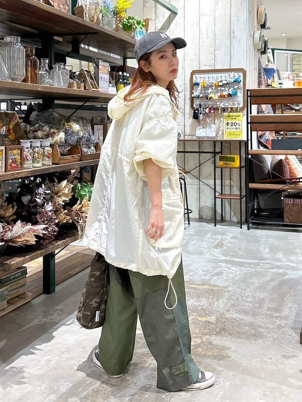 ベージュ系のブルゾン、グレー系のTシャツ/カットソー、ブラック系のキャップを着用したレディースの春コーディネートの4枚目の写真