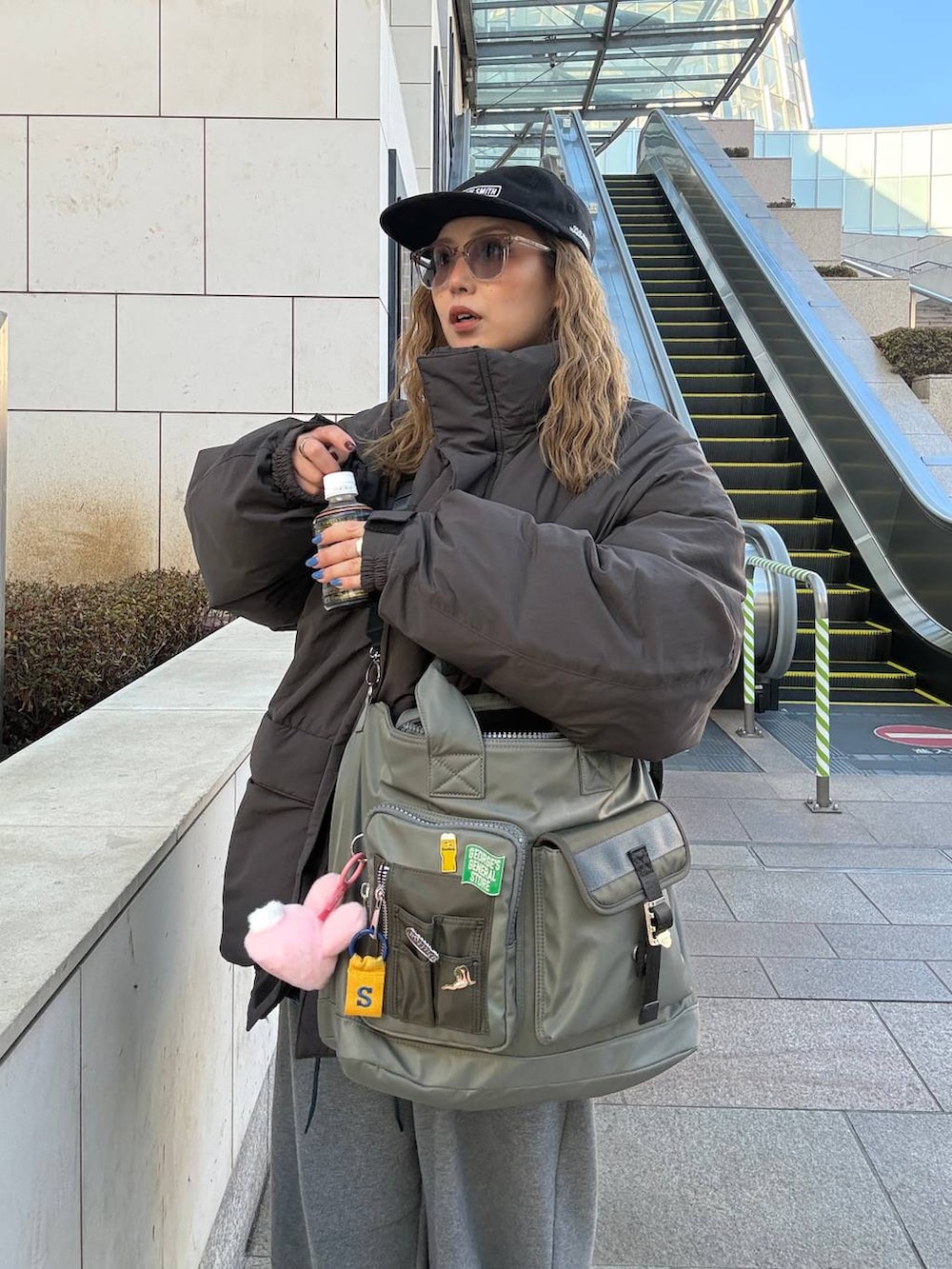 グレー系のその他パンツ、グレー系のダウンジャケット/コート、グリーン系のトートバッグを着用したレディースの冬コーディネートの3枚目の写真