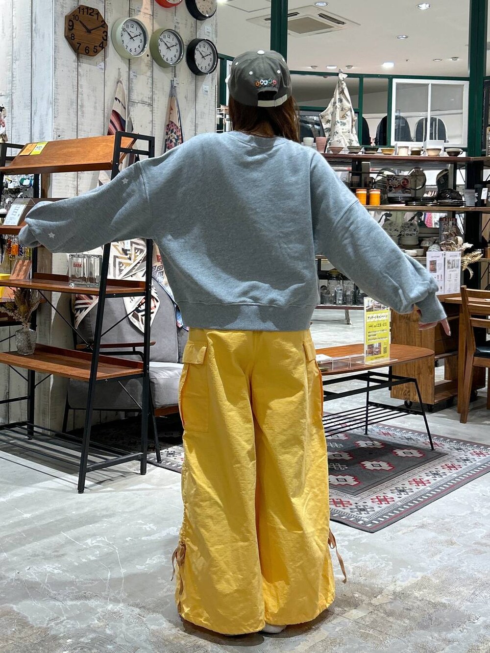 グレー系のスウェット、グリーン系のキャップを着用したレディースの冬コーディネートの5枚目の写真