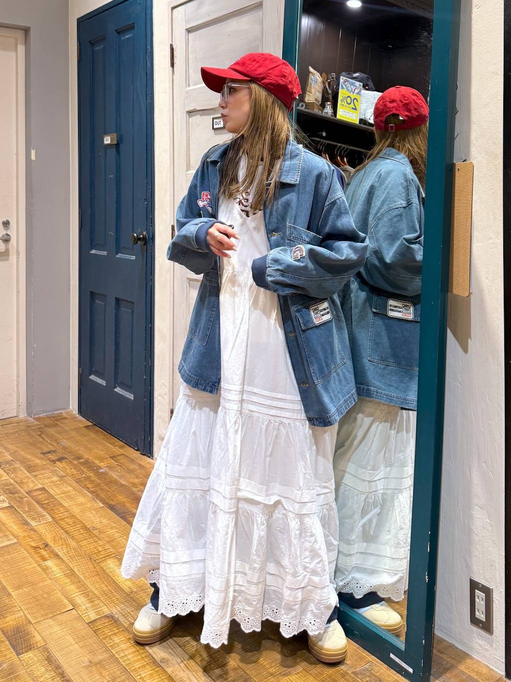 ベージュ系のスニーカー、レッド系のキャップを着用したレディースの春コーディネートの3枚目の写真