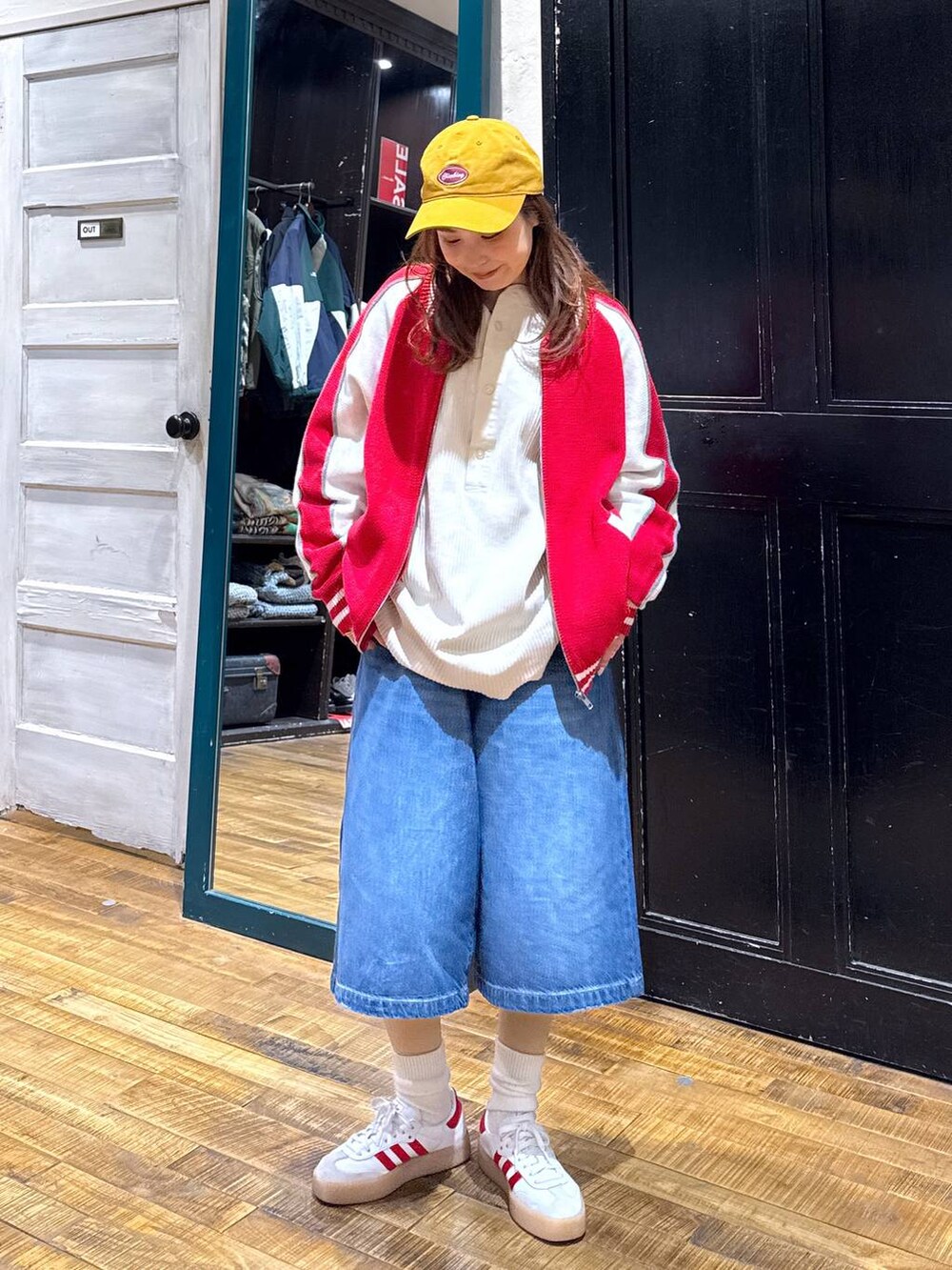 ブルー系のデニムパンツ、ホワイト系のTシャツ/カットソー、レッド系のカーディガン/ボレロを着用したレディースの冬コーディネートの3枚目の写真
