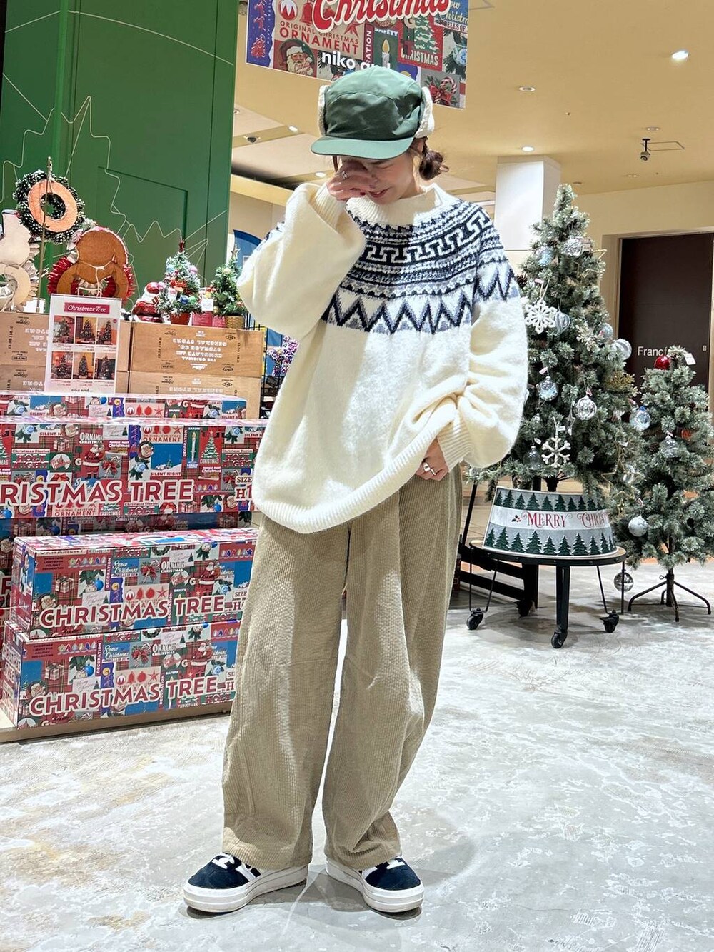 ベージュ系のニット/セーター、イエロー系のその他パンツ、グリーン系のキャップを着用したレディースの冬コーディネートの2枚目の写真