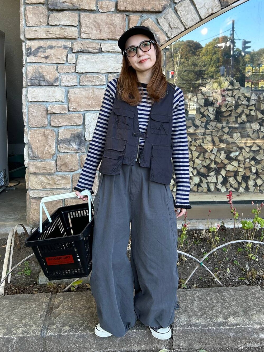 グレー系のベスト、ベージュ系のTシャツ/カットソー、ブラック系のキャップを着用したレディースの春コーディネートの3枚目の写真