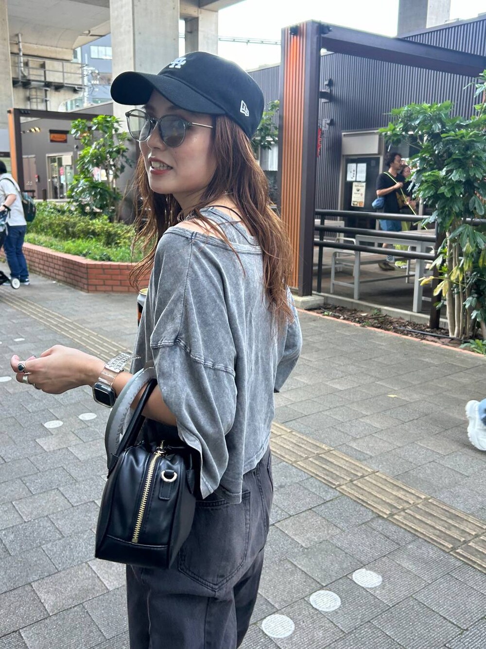 ブラック系のサンダル、ブラック系のデニムパンツ、グレー系のTシャツ/カットソーを着用したレディースの夏コーディネートの2枚目の写真