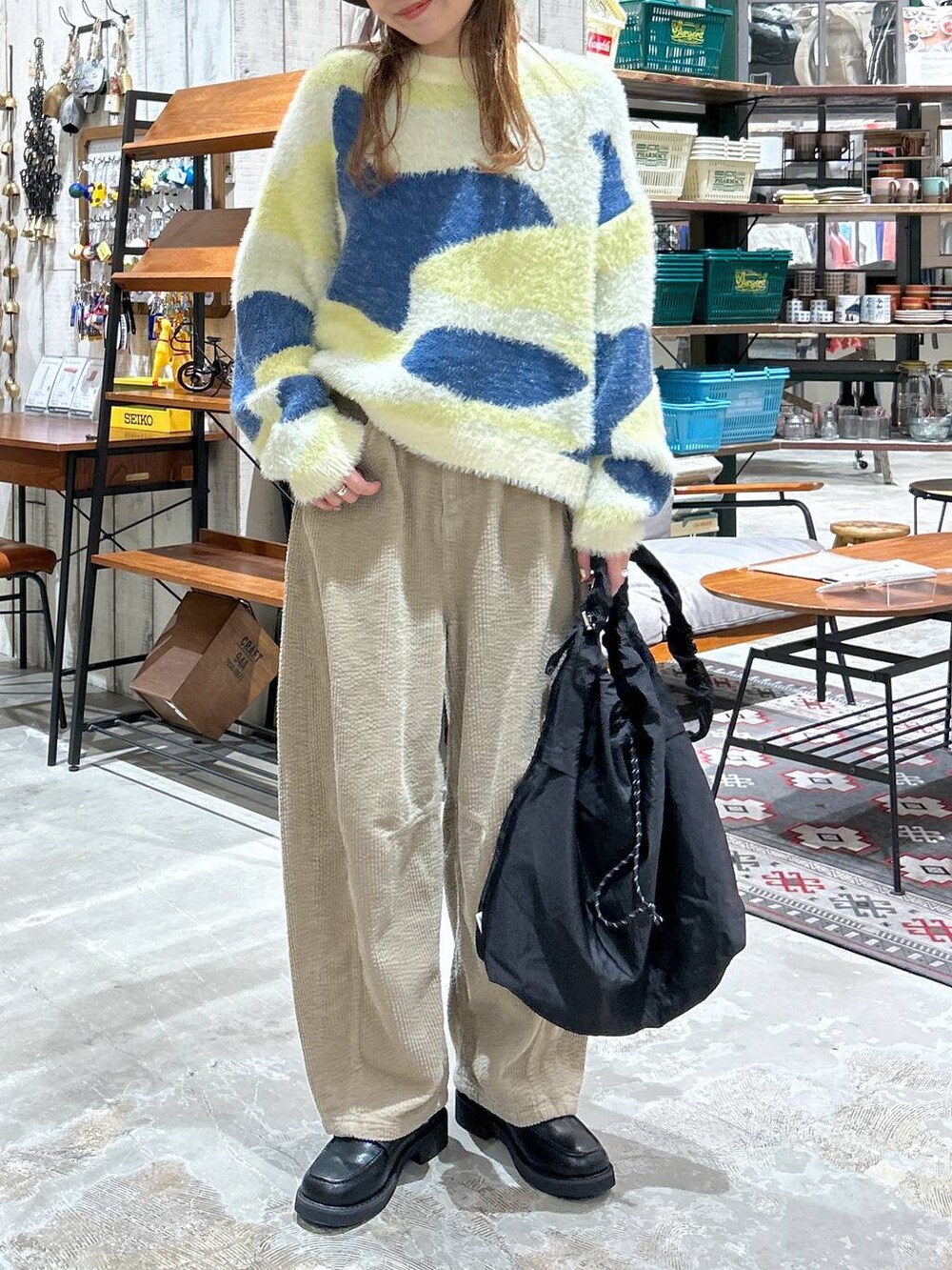 ブラック系のローファー、ブラック系のショルダーバッグ、イエロー系のその他パンツを着用したレディースの冬コーディネートの4枚目の写真