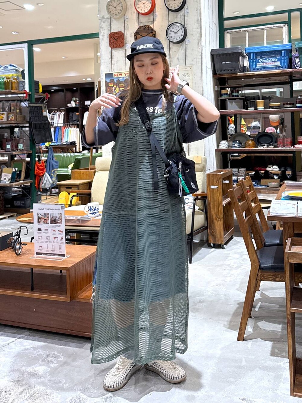 ブルー系のデニムパンツ、ブラック系のキャップを着用したレディースの春コーディネートの2枚目の写真