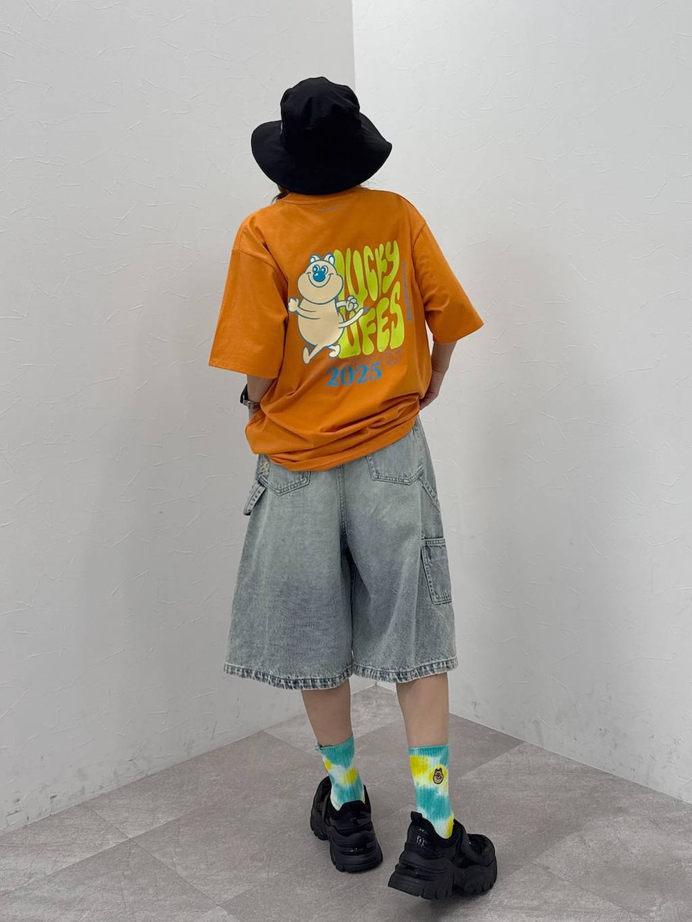 ブラック系のスニーカー、ブルー系のデニムパンツ、ブラック系のハットを着用したレディースの夏コーディネートの3枚目の写真