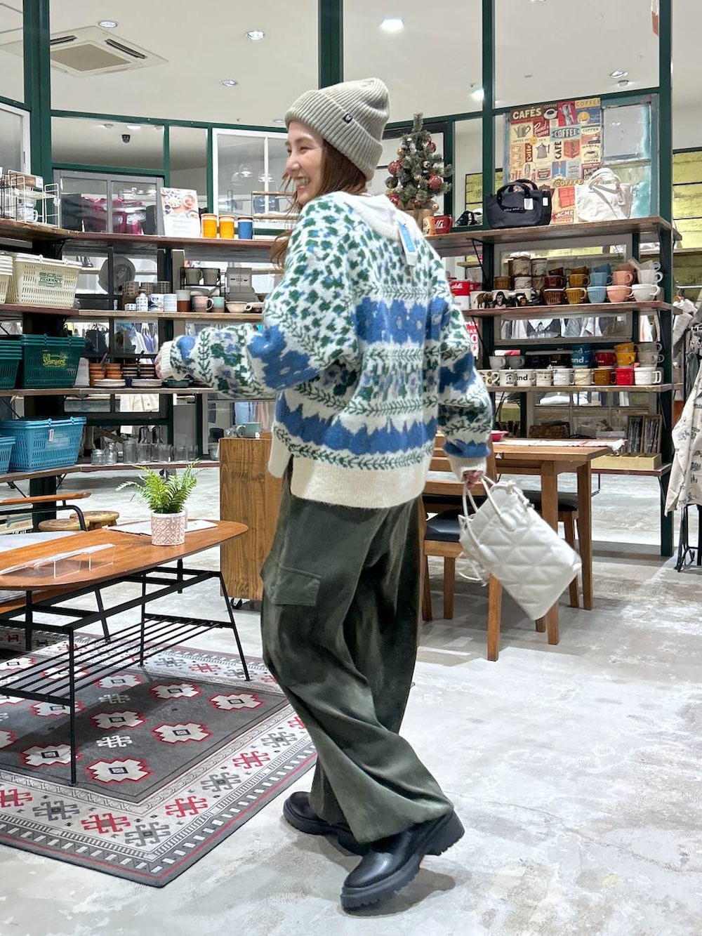 ベージュ系のショルダーバッグ、ブラック系のブーツ、グリーン系のカーゴパンツを着用したレディースの冬コーディネートの3枚目の写真