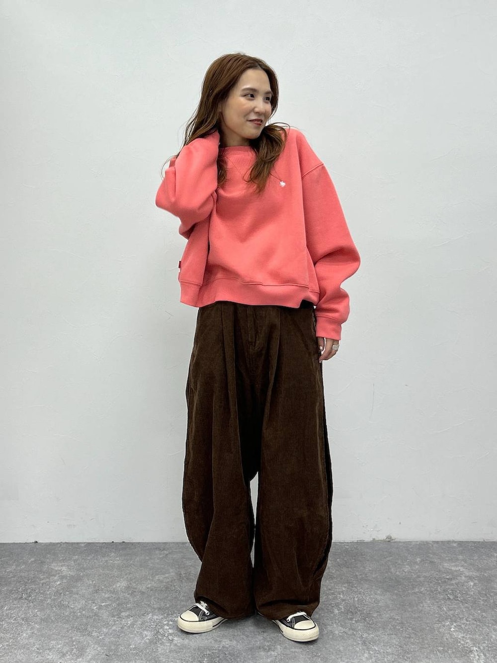 ピンク系のスウェットを着用したレディースの秋コーディネートの2枚目の写真