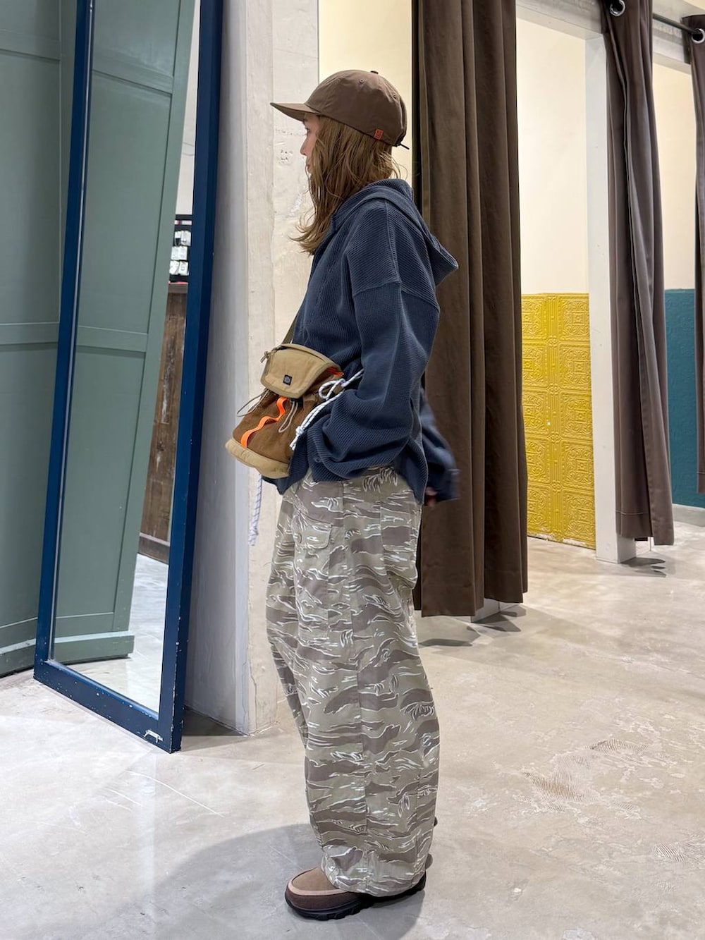 ブルー系のパーカー、ベージュ系のその他シューズ、ブラウン系のキャップを着用したレディースの冬コーディネートの4枚目の写真