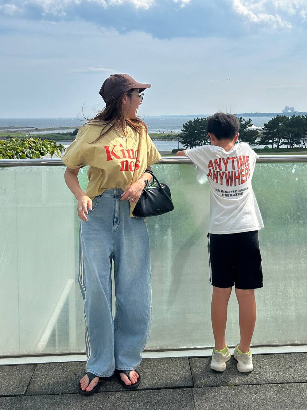 イエロー系のTシャツ/カットソー、ブラック系のサンダルを着用したレディースの夏コーディネートの2枚目の写真