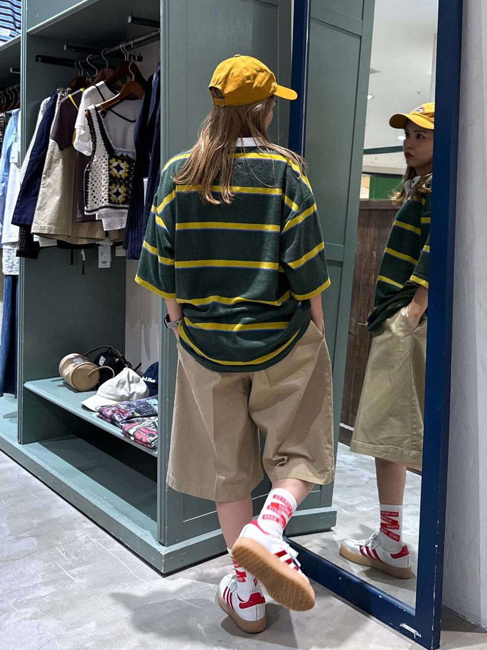 ベージュ系のその他パンツ、グリーン系のTシャツ/カットソー、イエロー系のキャップを着用したレディースの夏コーディネートの3枚目の写真