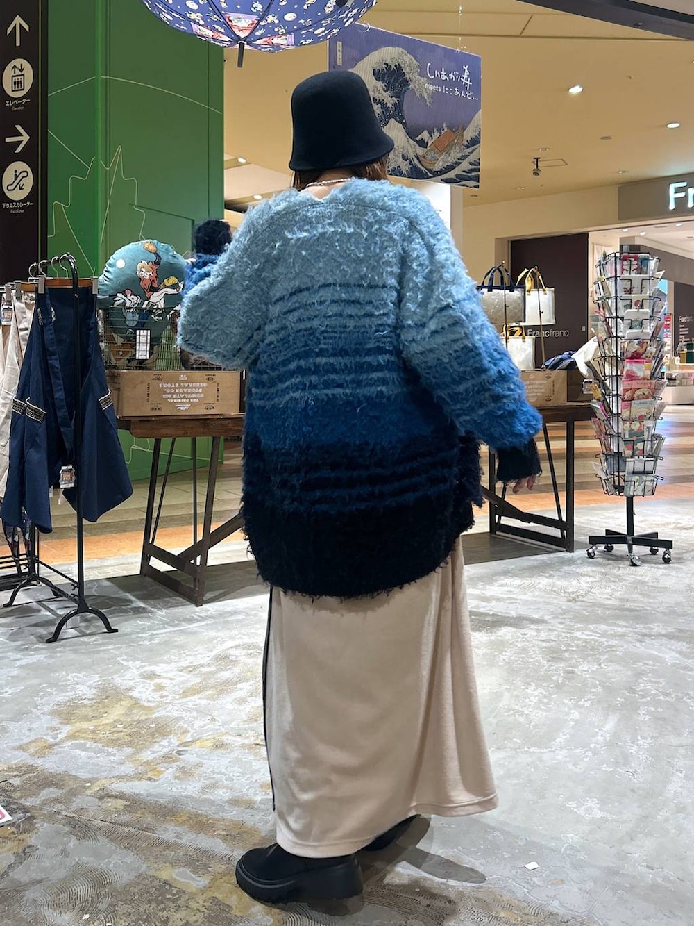 ブラック系のブーツ、ホワイト系のその他トップス、ベージュ系のスカートを着用したレディースの冬コーディネートの4枚目の写真