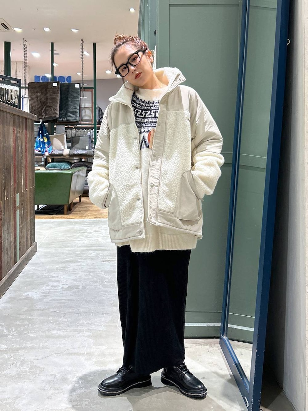 ベージュ系のその他アウター、ブラック系のブーツ、ブラック系のスカートを着用したレディースの冬コーディネートの2枚目の写真