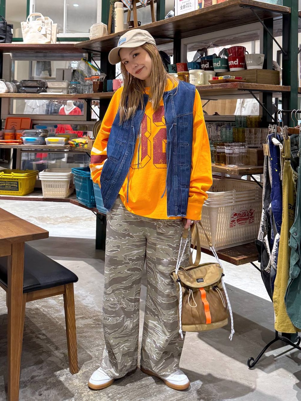 ブルー系のベスト、ベージュ系のキャップを着用したレディースの春コーディネートの4枚目の写真