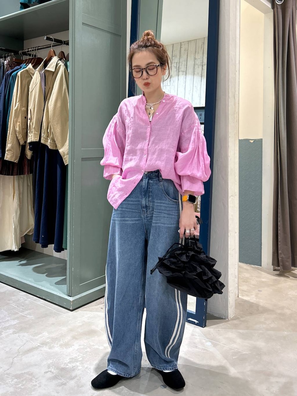 ブラック系のショルダーバッグ、ブラック系のパンプス、ピンク系のシャツ/ブラウスを着用したレディースの春コーディネートの2枚目の写真