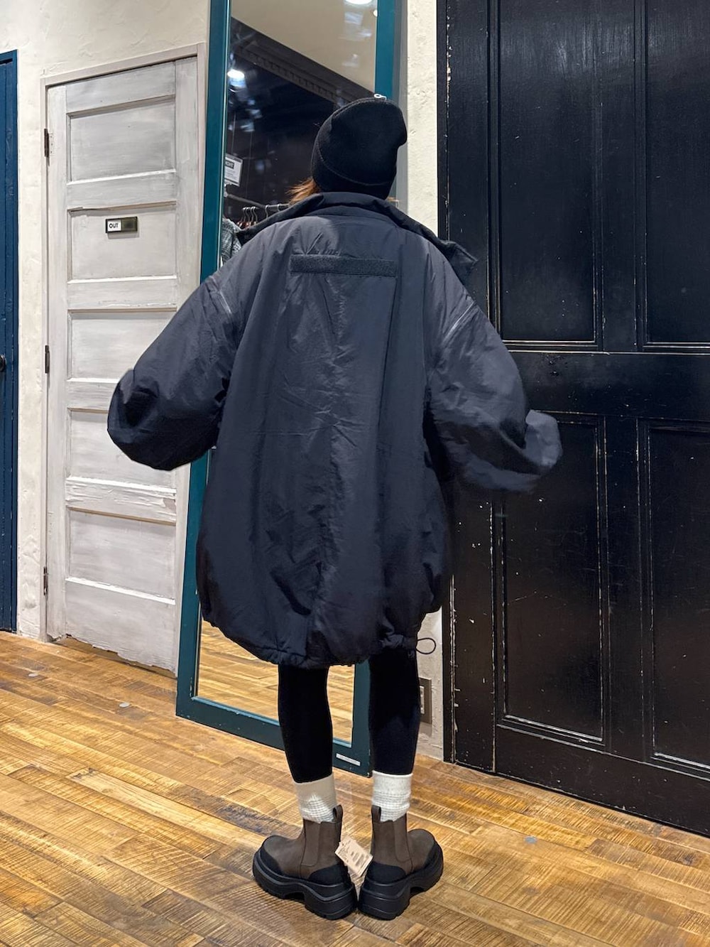 ブラック系のナイロンジャケット、ブラウン系のブーツ、ブラウン系のカーディガン/ボレロを着用したレディースの秋コーディネートの5枚目の写真