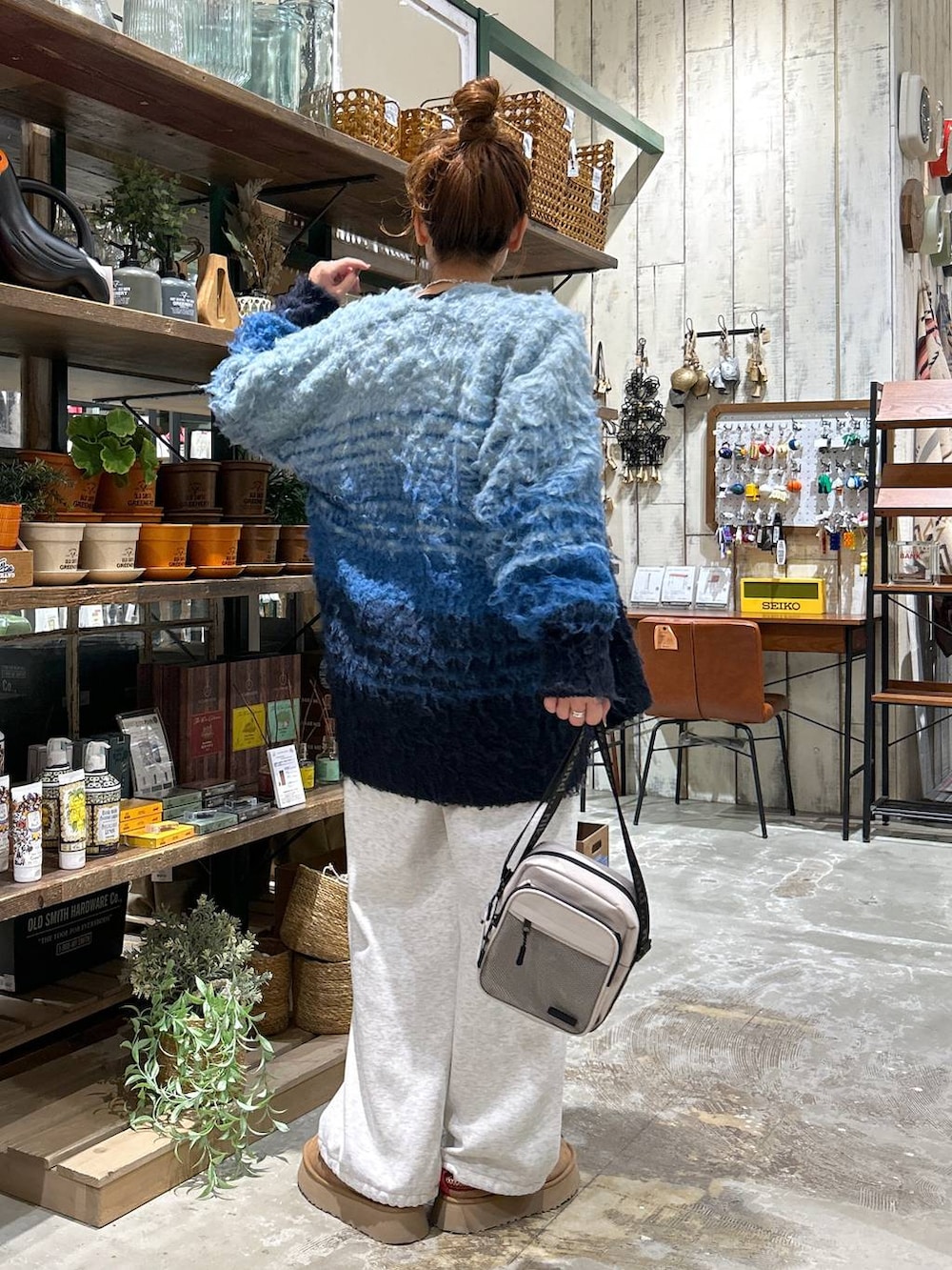 イエロー系のショルダーバッグ、ベージュ系のスウェットパンツ、ブルー系のその他トップスを着用したレディースの冬コーディネートの3枚目の写真