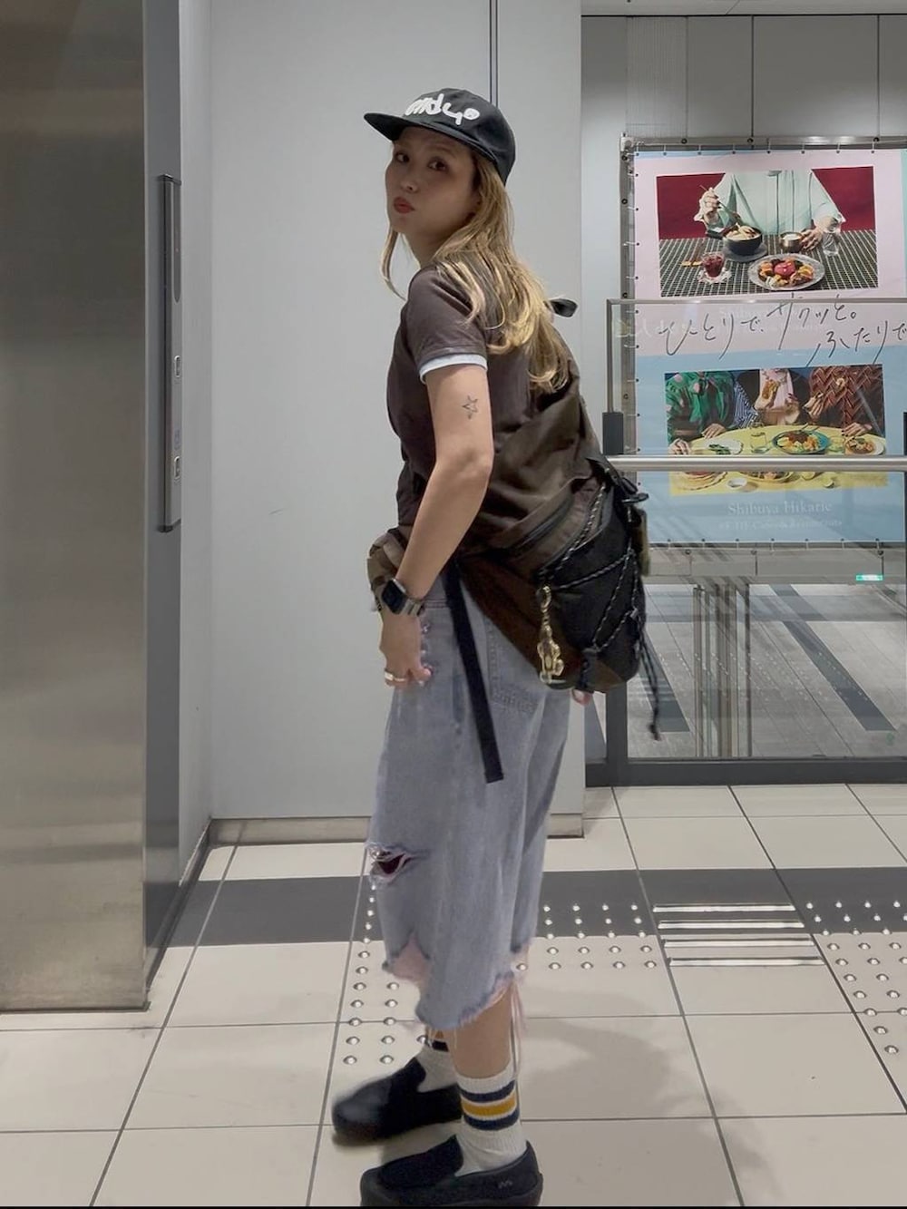 ピンク系のデニムパンツ、ブラウン系のTシャツ/カットソー、ベージュ系のボディバッグ/ウエストポーチを着用したレディースの夏コーディネートの3枚目の写真