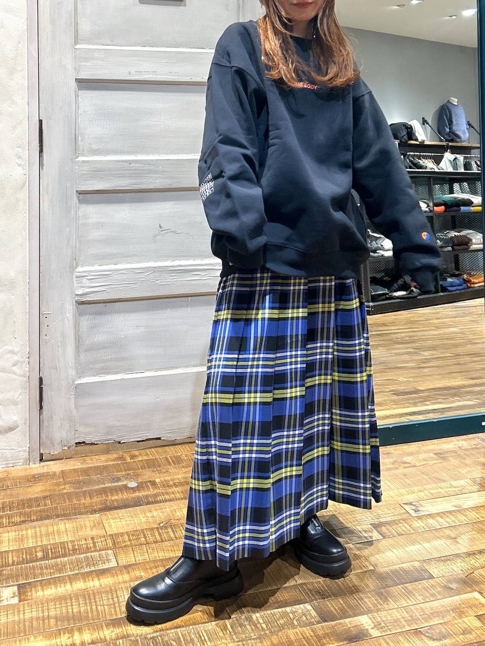 ブルー系のスカート、ブラック系のブーツ、その他のスウェットを着用したレディースの冬コーディネートの2枚目の写真