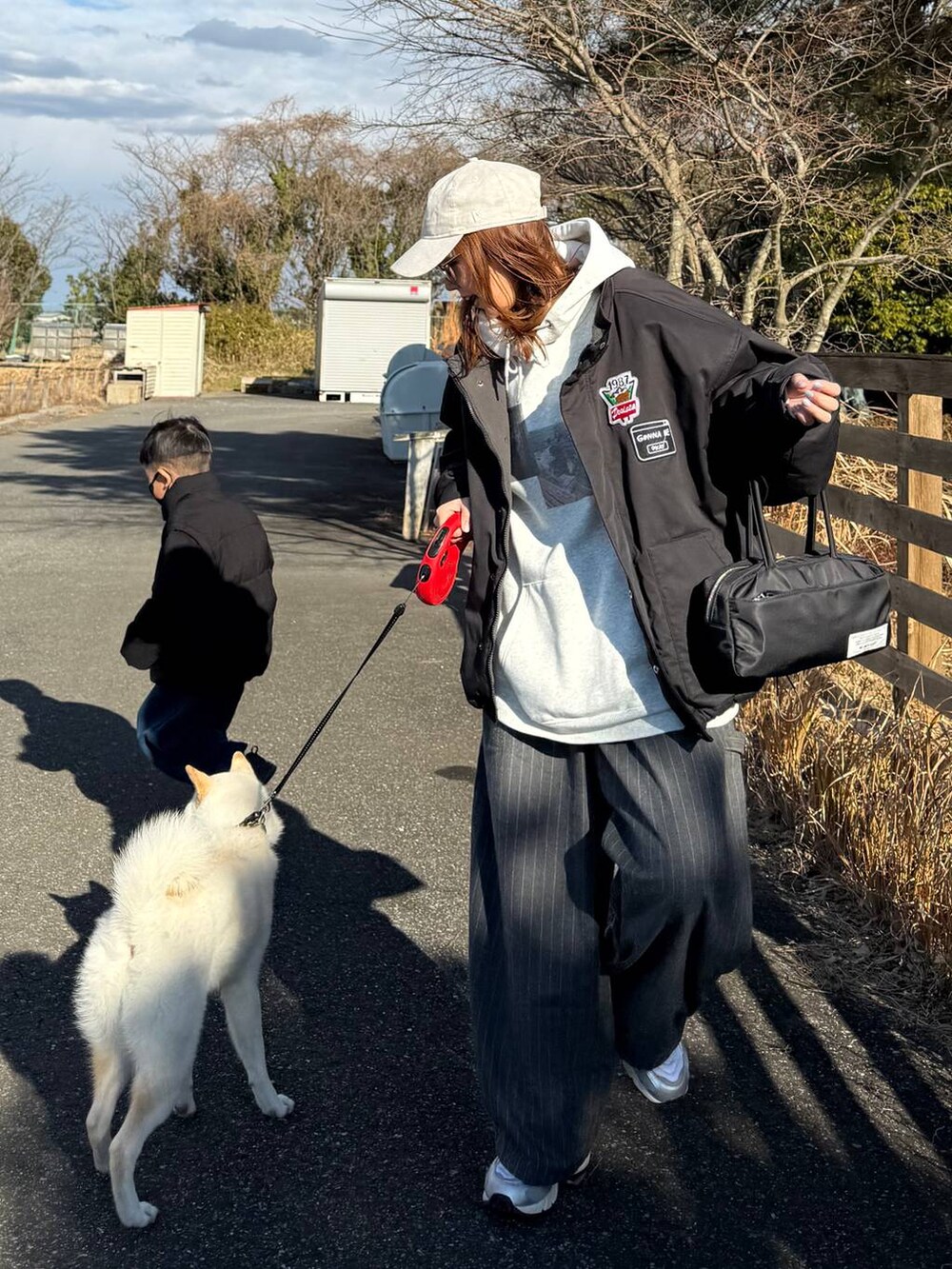 ブラック系のボストンバッグ、グレー系のその他パンツを着用したレディースの冬コーディネートの2枚目の写真