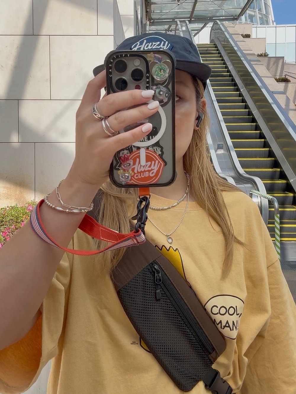 オレンジ系のTシャツ/カットソーを着用したレディースの夏コーディネートの4枚目の写真