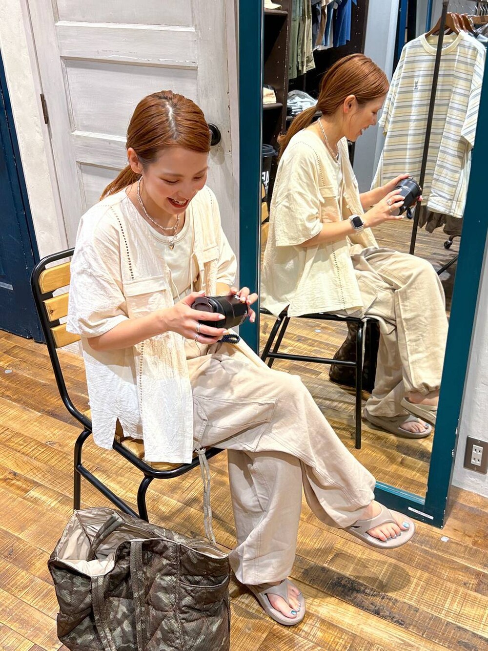 ブラウン系のトートバッグ、ベージュ系のカーゴパンツ、ブラック系のグラス/マグカップ/タンブラーを着用したレディースの夏コーディネートの2枚目の写真