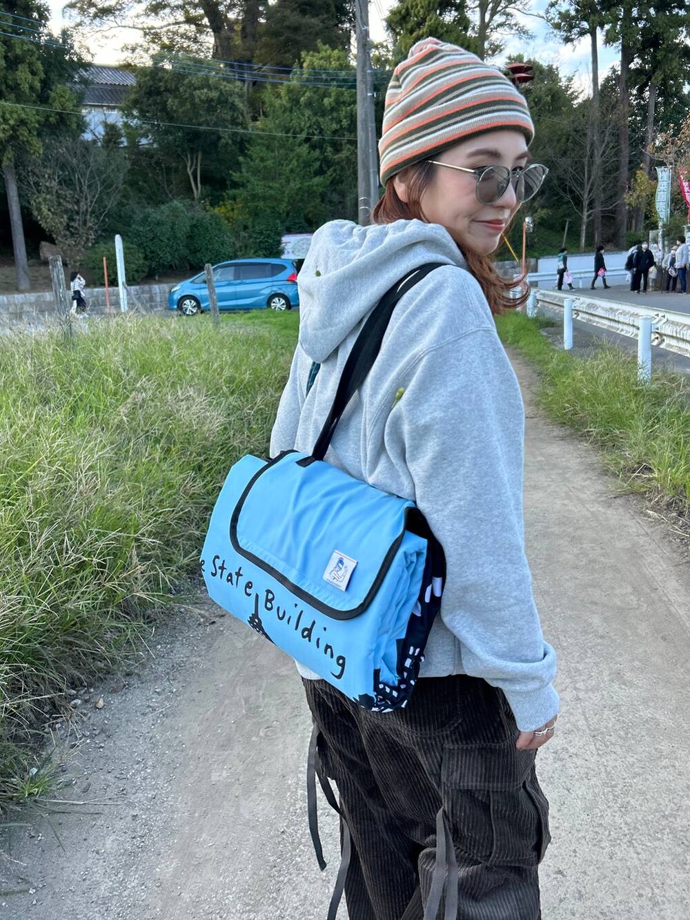 ブラウン系のカーゴパンツ、グレー系のパーカー、グレー系のショルダーバッグを着用したレディースの秋コーディネートの3枚目の写真